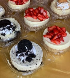 six desserts in plastic containers with strawberries and cookies on the top one is white