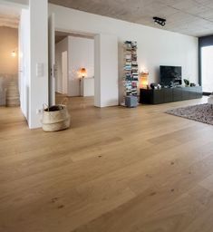 a living room filled with furniture and a flat screen tv on top of a wooden floor