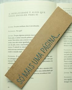 an open book with the words spanish and english on it next to a paper stick