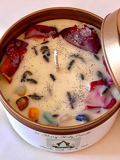 a bowl filled with fruit and cream sitting on top of a white table next to a container