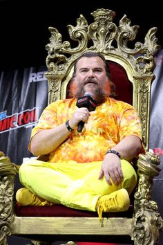 a man sitting in a chair holding a microphone