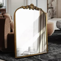 a large mirror sitting on top of a floor next to a couch