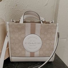 Coach Tote Bag In Great Used Condition Has Some Minor Wear On The Bottom ( Second Picture) But Can Be Cleaned Detachable Strap Measurements: Length: 8.75" Height: 6.25" Width: 4.25" Coach Beige Shoulder Bag With Dust Bag, Beige Coach Shoulder Bag With Dust Bag, Coach Beige Bucket Bag, Coach Beige Rectangular Bag, Coach White Large Capacity Shoulder Bag, Coach Double Handle Canvas Bag, Coach Canvas Bags With Double Handle, Coach Canvas Bag With Double Handles, Coach Canvas Bag With Removable Pouch