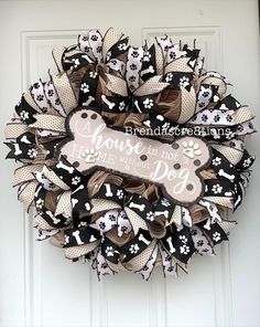 a black and white dog themed wreath on a door with the words house is not a home without a dog