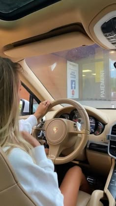 a woman sitting in the driver's seat of a car