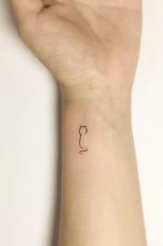 a person's arm with a small tattoo on the left side of their wrist