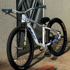 a bike parked next to a building on the side of the street with it's front wheel missing