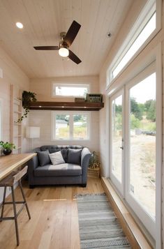 an instagramted photo of a living room with a couch, table and ceiling fan