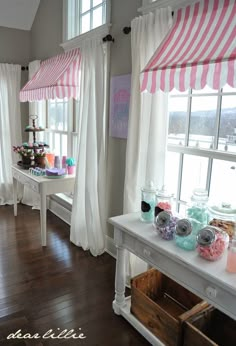 a room filled with lots of windows covered in pink and white curtains