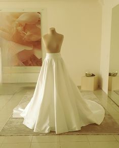 a white wedding dress on display in a room