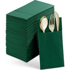 a stack of green napkins with gold forks and spoons on top of them