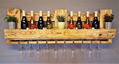 a wooden wine rack filled with bottles and glasses