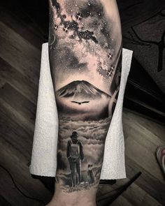 a man's arm with a tattoo on it and an image of a mountain in the background