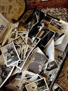 an open suitcase filled with old photos and other items on the floor next to a wall