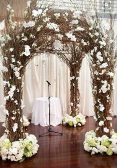 the wedding arch is decorated with white flowers