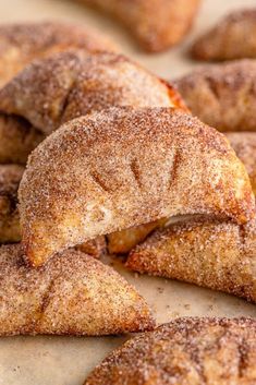 powdered sugar filled pastries on a baking sheet with other pastries in the background