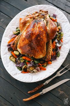 a white plate topped with a turkey and vegetables