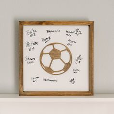 a wooden frame with writing on it and a soccer ball drawn on the wall behind it