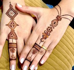 two hands with henna tattoos on them