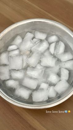 ice cubes in a metal bowl on a wooden table