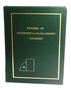 a green book with gold lettering on the front and back cover, which reads pioneers of southwest la plaza county