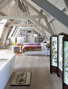 an attic bedroom with white walls and wooden floors