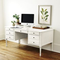 a white desk with a computer on top of it and a chair in front of it