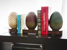 some books are sitting on a shelf next to two pineapple shaped bookends