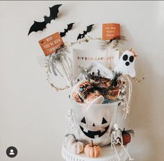 a white bucket filled with halloween treats and decorations on top of a table next to a card