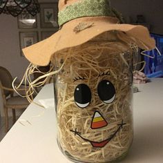 a mason jar with straw in the shape of a scarecrow's face and hat