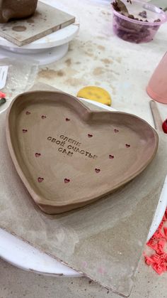 a heart shaped dish sitting on top of a table