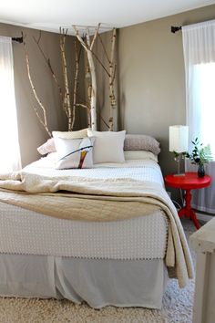 a white bed sitting in a bedroom next to a window