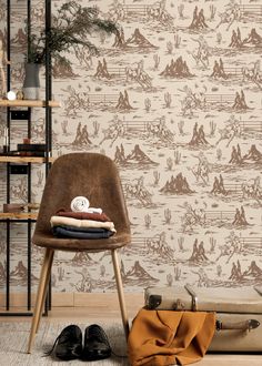 a brown chair sitting on top of a wooden floor next to a wallpaper covered in animals