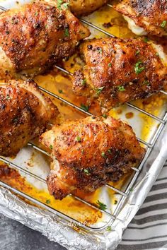 baked chicken legs on a baking sheet with lemon sauce and parsley in the background