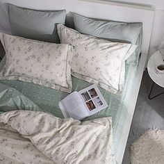 a bed with two pillows and a magazine on it