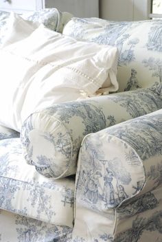 an upholstered couch with blue and white toiler print on the back