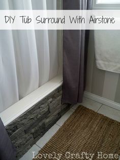 a bathroom with a shower curtain, rug and window sill on the side of the bathtub