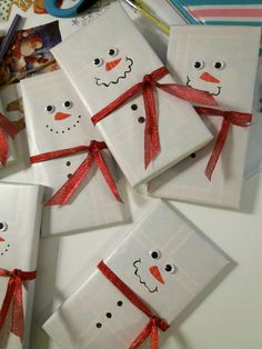 these snowmen are made out of paper and tied together with red ribbon on them