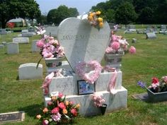 flowers are placed on the headstones of many different people in a cemetery with pink and yellow flowers