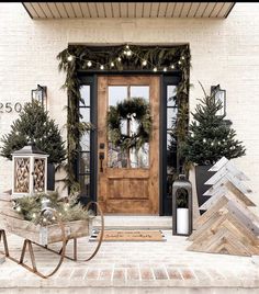 the front door is decorated for christmas with wreaths and pine trees