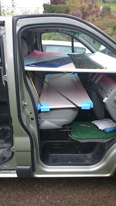 the back door of a green truck with surfboards on it's rack and other items