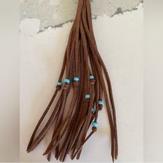 a bunch of braids with turquoise beads hanging from it's end on a wall