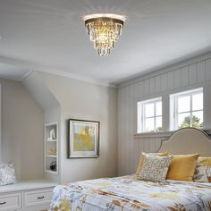 a bed room with a neatly made bed and a chandelier hanging from the ceiling