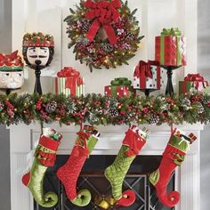 christmas stockings hanging from a mantel decorated with holiday decorations