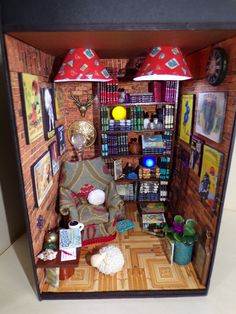 a doll house with furniture and pictures on the walls, including a couch in front of a bookshelf