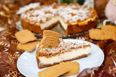 a slice of cheesecake on a plate with crackers next to it and some cookies