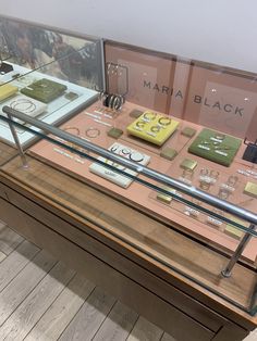 there is a display case with many different items on the glass and wood table top