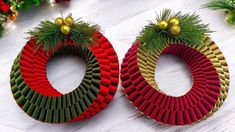 two christmas wreaths made out of red, green and gold paper on top of a white table