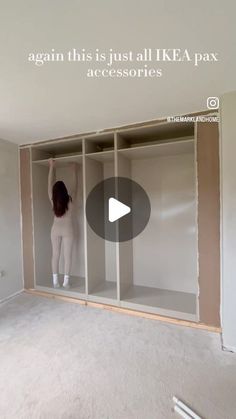 a woman is standing in the middle of an empty room with shelving and shelves