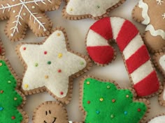 decorated cookies are arranged on a white surface with snowflakes and candy canes